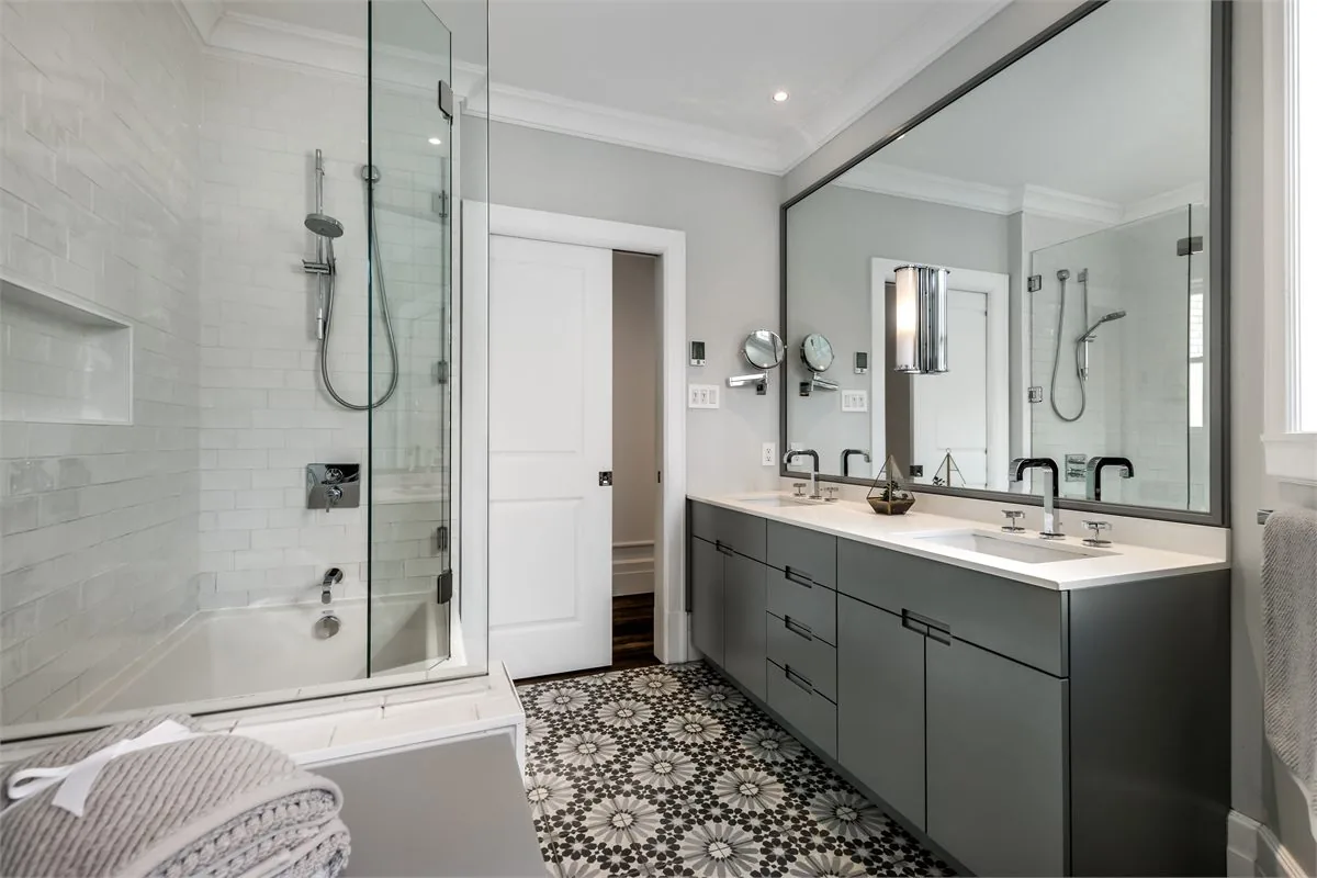 Full bathroom remodel with double vanity, tiled shower, bathtub, frameless glass, and patterned tile flooring.